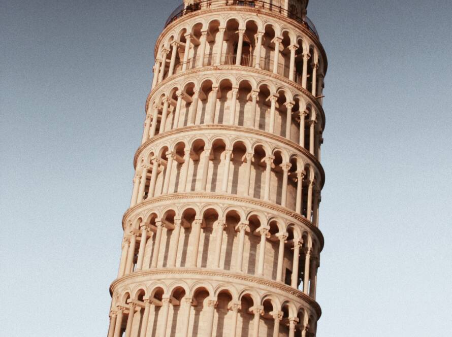 The Leaning Tower of Pisa, a famous landmark, is depicted leaning at an angle with a clear sky in the background.