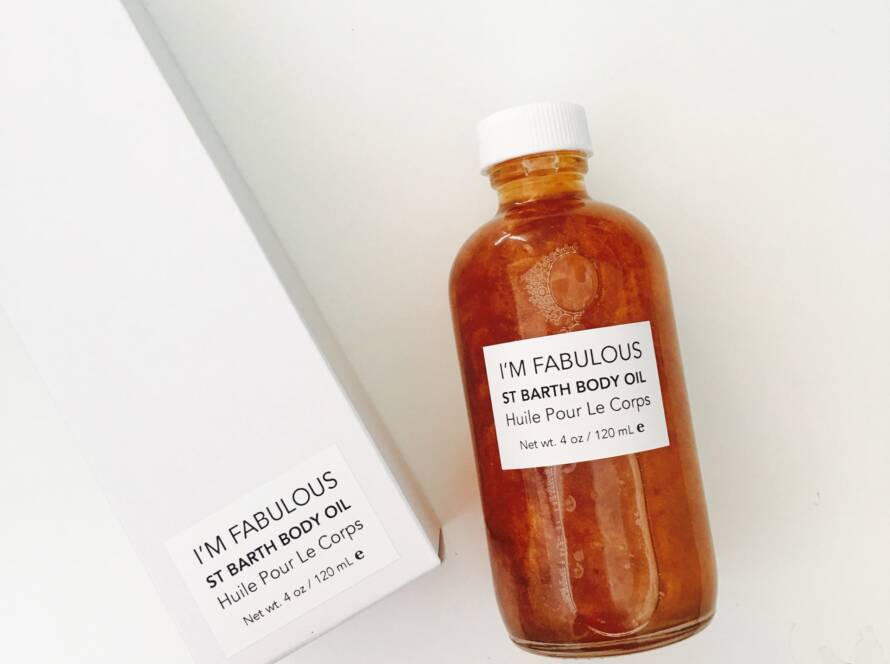 A bottle of I'M FABULOUS St Barth body oil with its box, both on a white background.